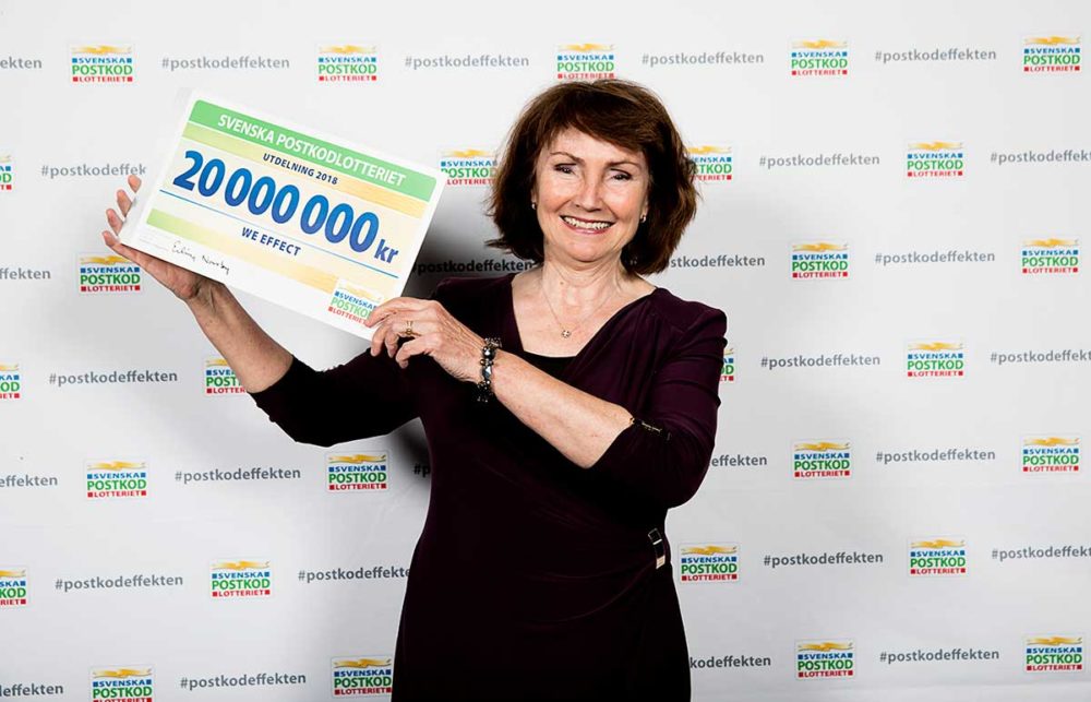 Anneli Rogeman håller upp en stor check med beloppet 20 miljoner.